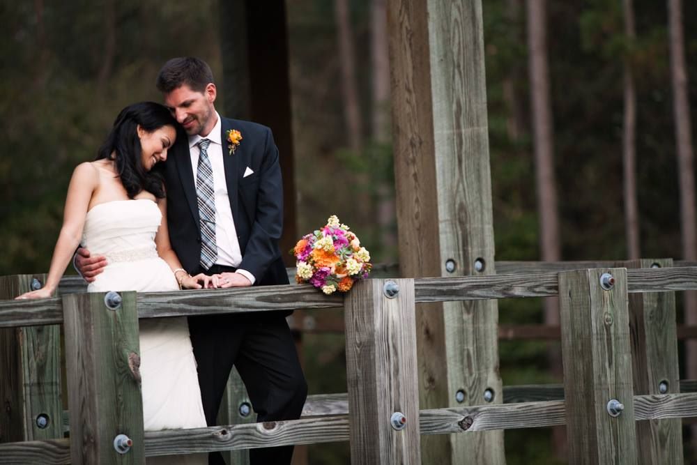 Description updated: A bride and groom exchanging vows on a wooden bridge with the assistance of an experienced NC wedding DJ.
