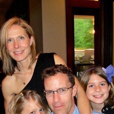 A man and woman posing for a photo with their children.