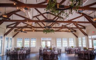 A wedding reception in a large room with wooden beams.