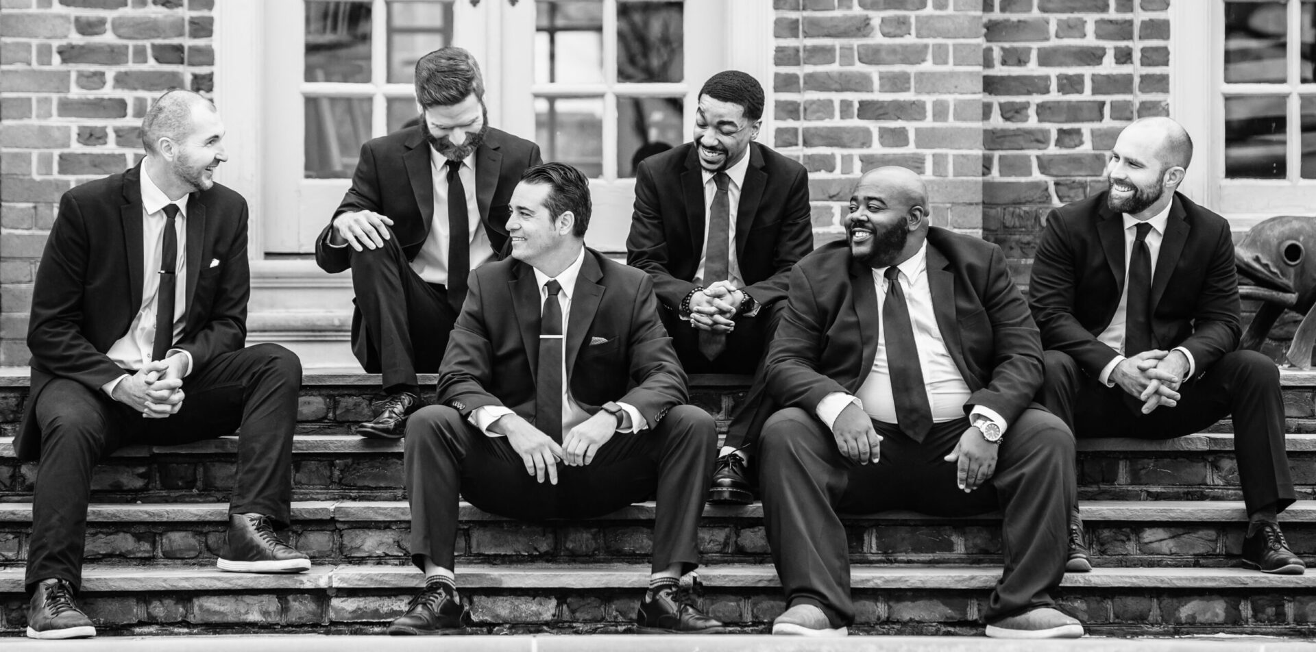 AwesomesaucePhotography2024-41 copy A group of men in suits sitting on steps.