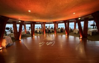 The dance floor at a wedding reception with a view of the ocean.