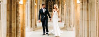 A bride and groom walking through a cathedral.