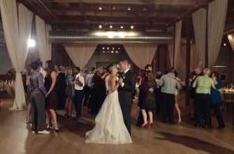 A bride and groom dancing in a large room.