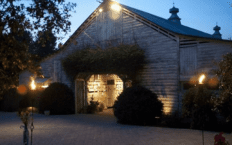 A large barn illuminated with romantic lighting, ideal for a magical wedding reception with a talented DJ in Fearrington Village.