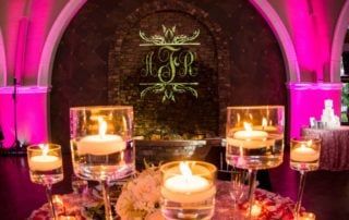 A wedding reception with candles and pink lighting.