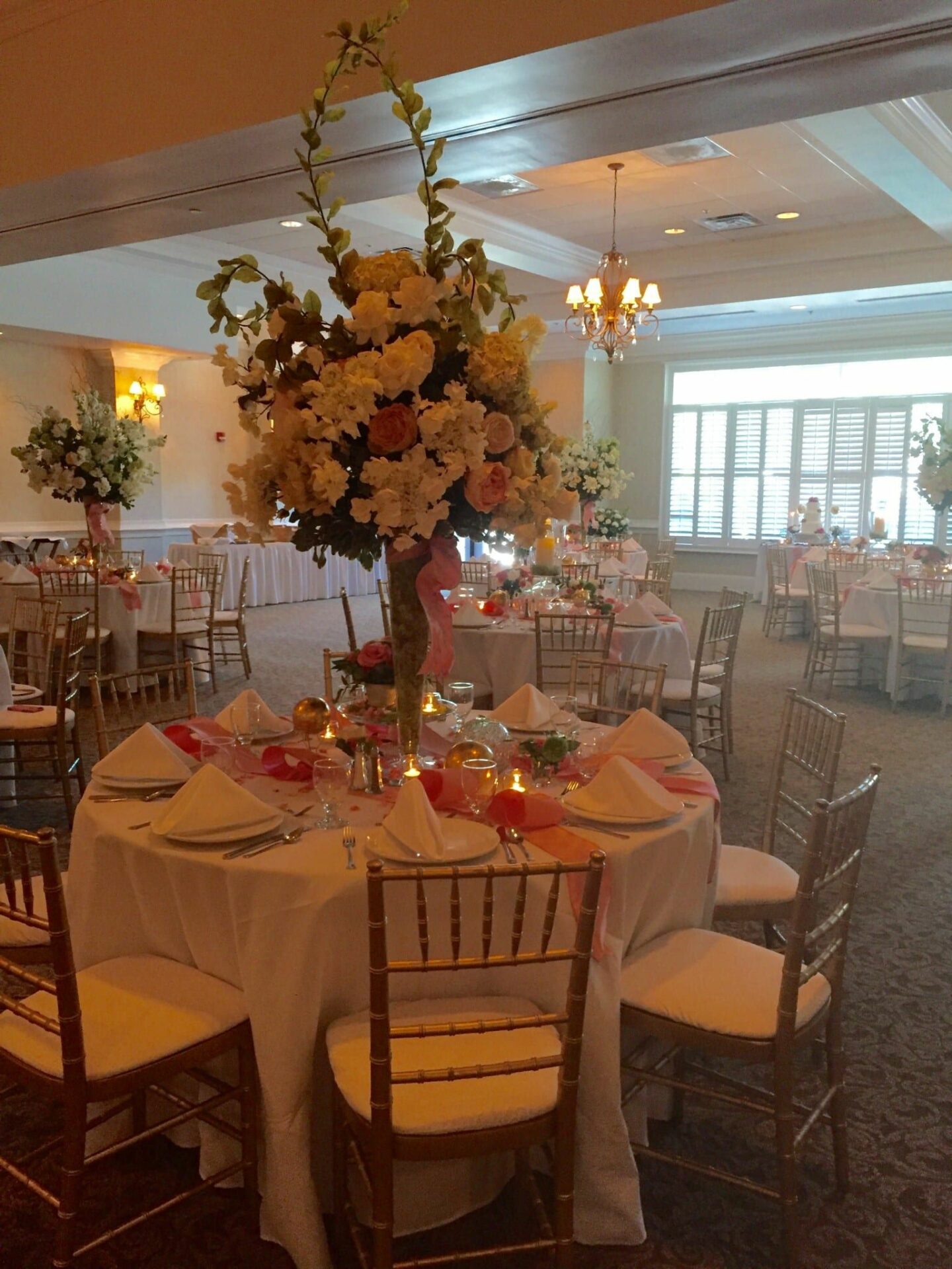 A large room with tables and chairs set up for a North Hills Club wedding.