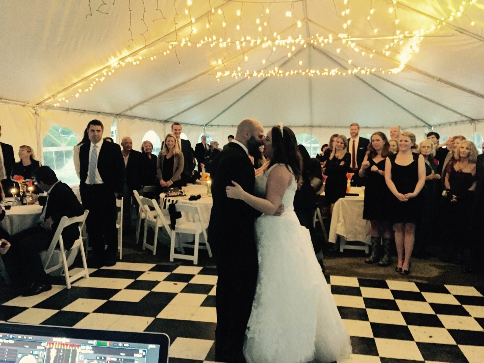 A bride and groom sharing their first dance with the accompaniment of a Wedding DJ in a tent.