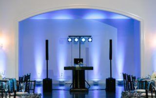 A room with blue lighting and a dj set up.