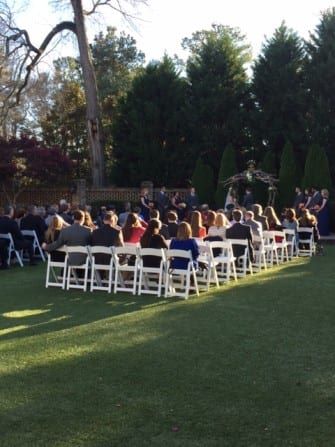 A wedding ceremony at The Sutherland, a picturesque venue nestled in a grassy area with elegantly arranged chairs.