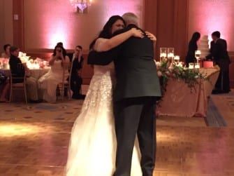 A bride and groom hugging on the dance floor at Umstead Hotel.
