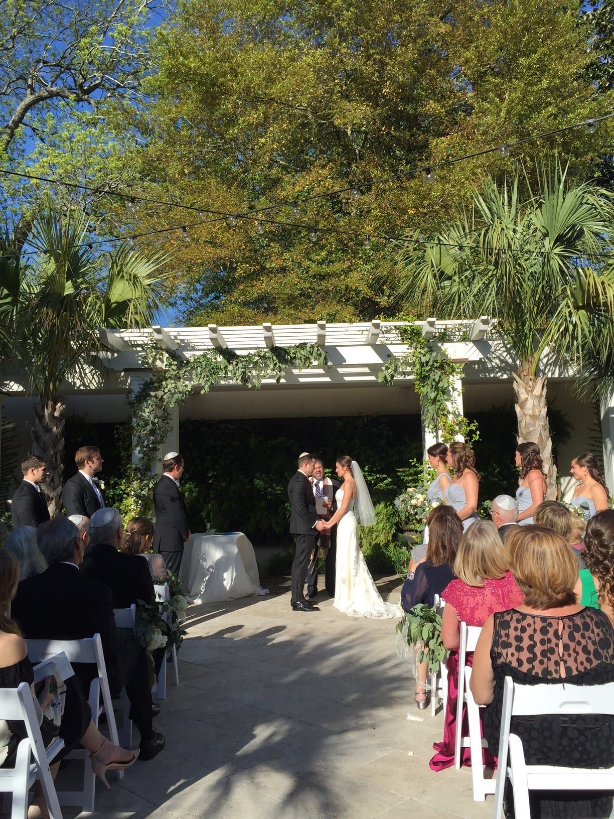 A cannon green wedding ceremony under a palm tree.