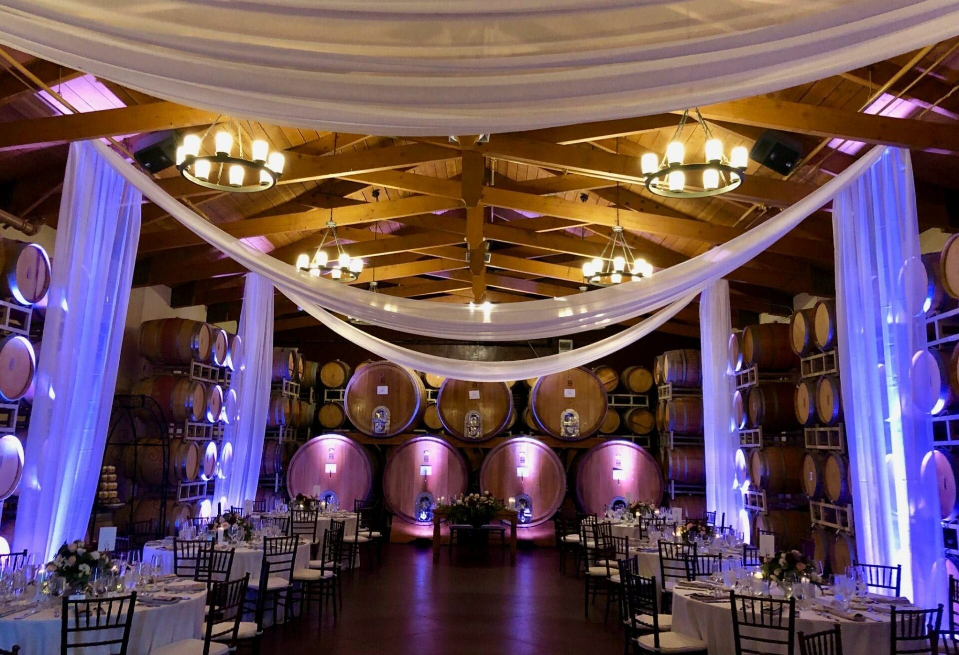 A wedding reception in a wine cellar with blue lighting.