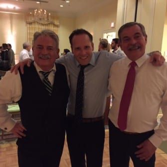 Three men posing for a photo at the Carolina Inn party.