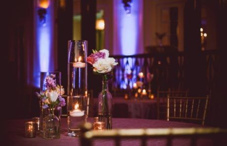 A table with candles and flowers on it.