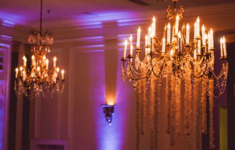 A chandelier in a room with purple lighting.