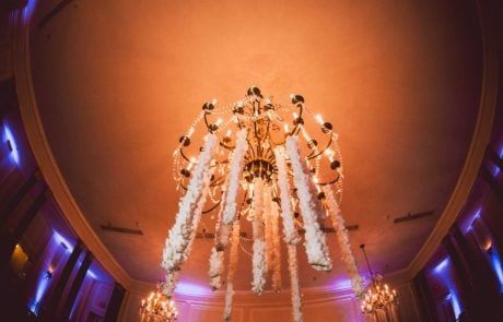 A chandelier hanging from a ceiling in a ballroom.