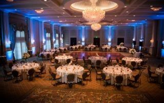 A large ballroom with tables and chairs set up for a wedding reception.
