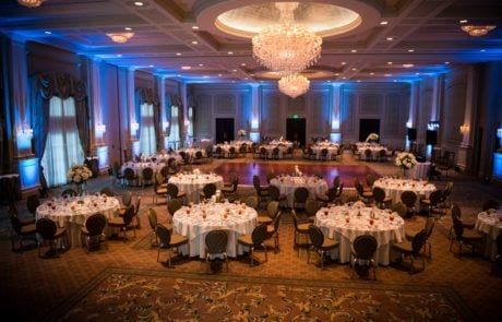A large ballroom with tables and chairs set up for a wedding reception.