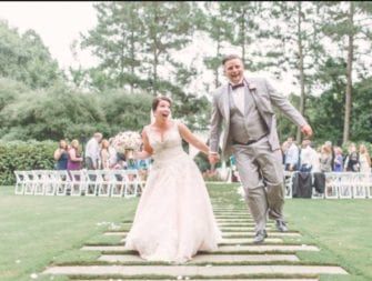 A bride and groom walking down a path at the Umstead Hotel wedding.