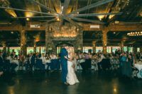 A bride and groom sharing their first dance in a rustic barn.
