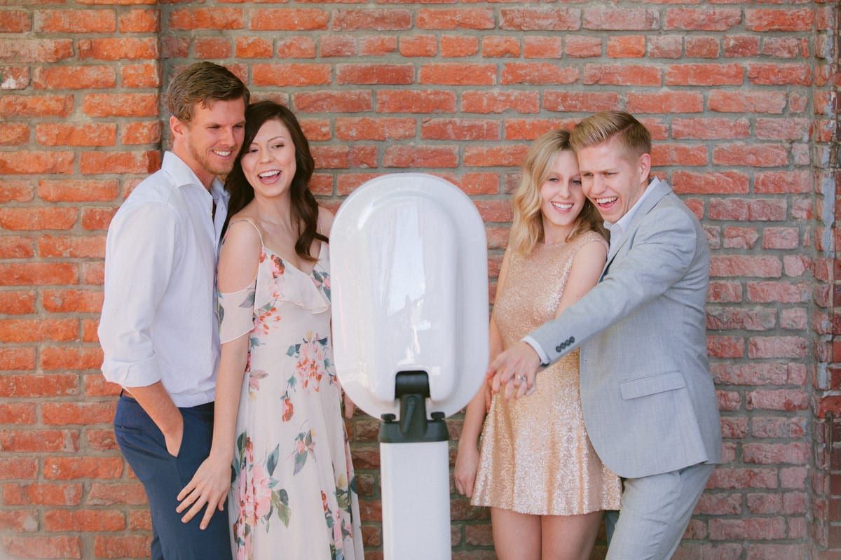 A group of people posing in front of a parking meter.
