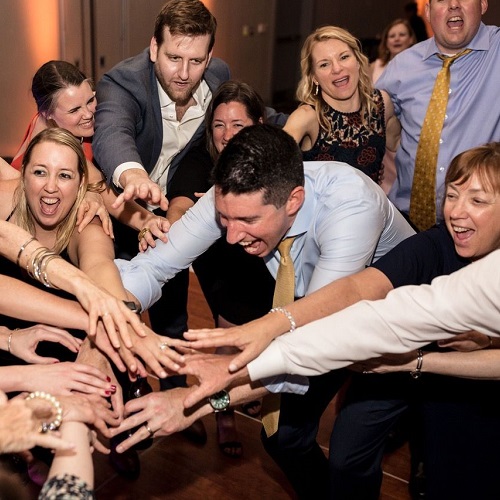 A group of people making a hula hoop at a wedding.