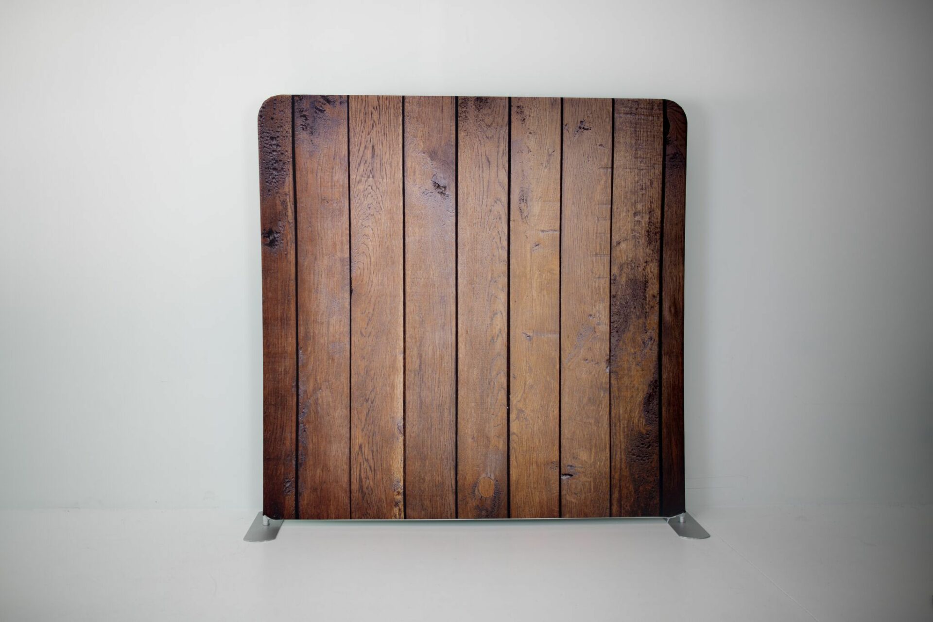 A wooden plank on a stand in front of a white wall.
