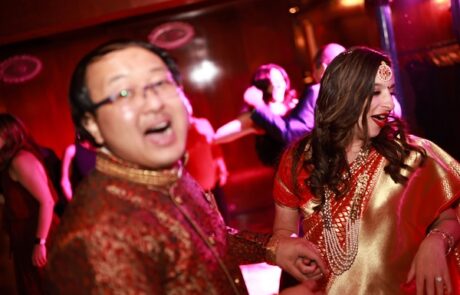 A bride and groom dancing on the dance floor at an indian wedding.