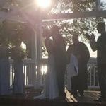 A bride and groom kissing under a gazebo.