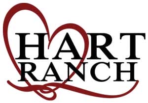 Logo with the words "Hart Ranch" in bold black letters, overlaid on a red heart-shaped outline.
