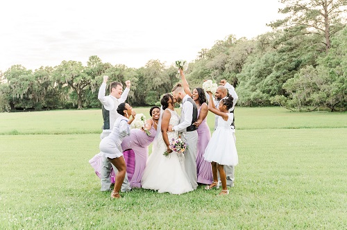A group of bridesmaids posing for a photo in a field.